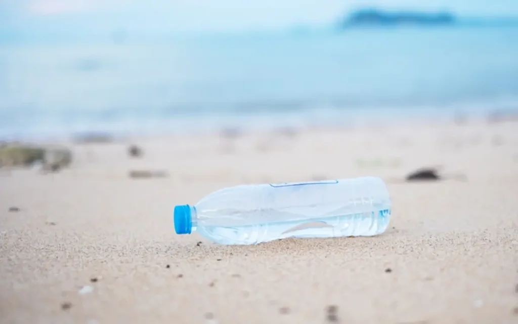 Butelka na plaży nad oceanem canva